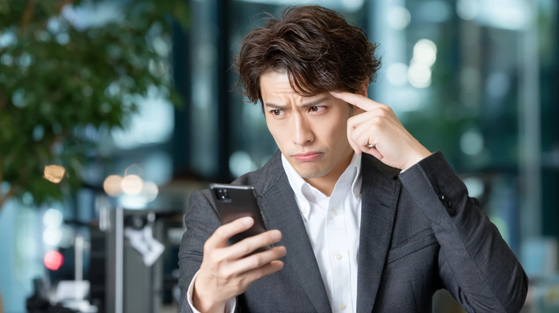 クーポンエラーに困る日本人男性がスマホを見つめる様子